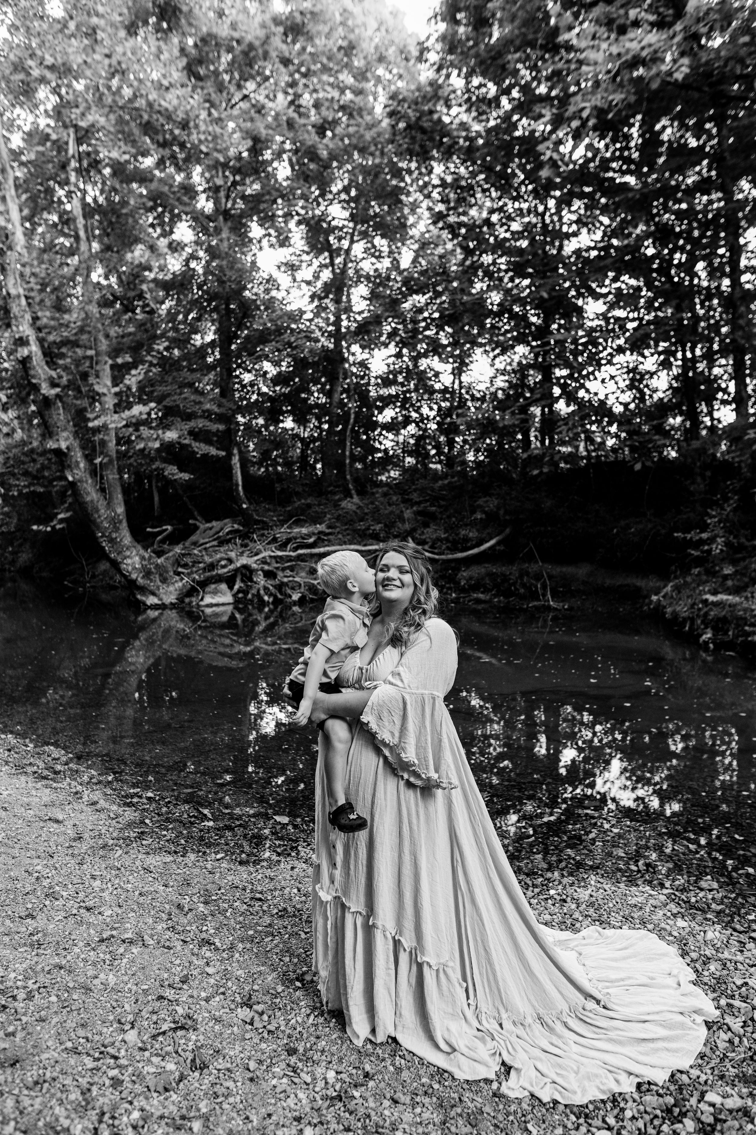 A romantic black and white photograph showing flowing dresses in a wooded setting.