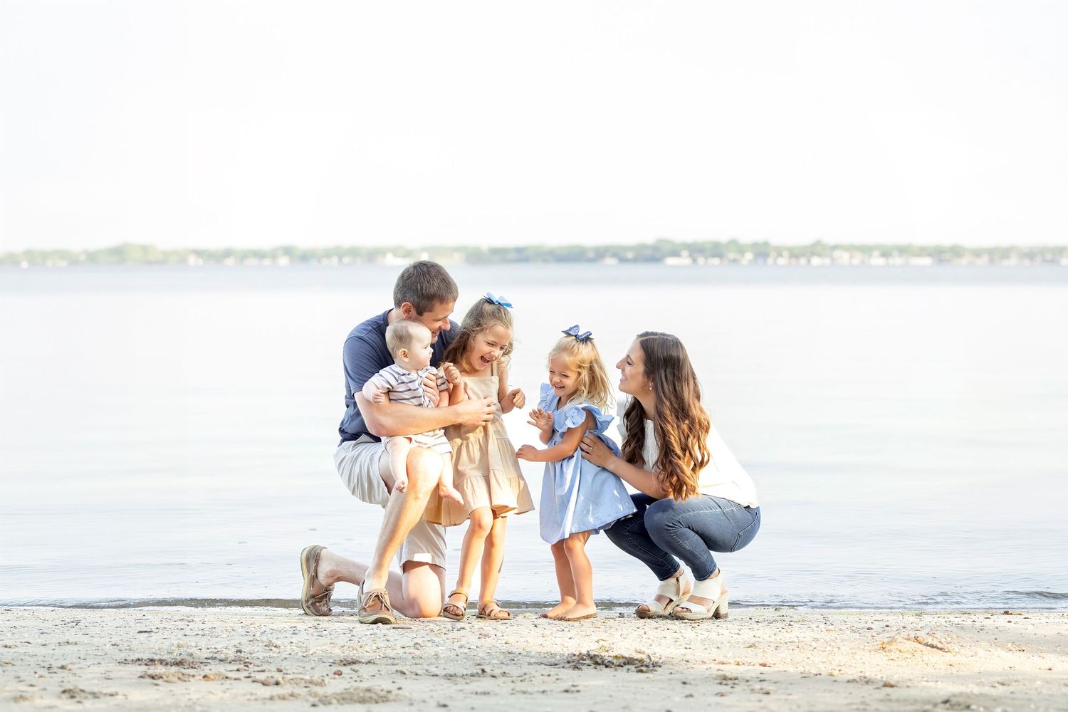 A family walks along a sandy beach together on a sunny day.