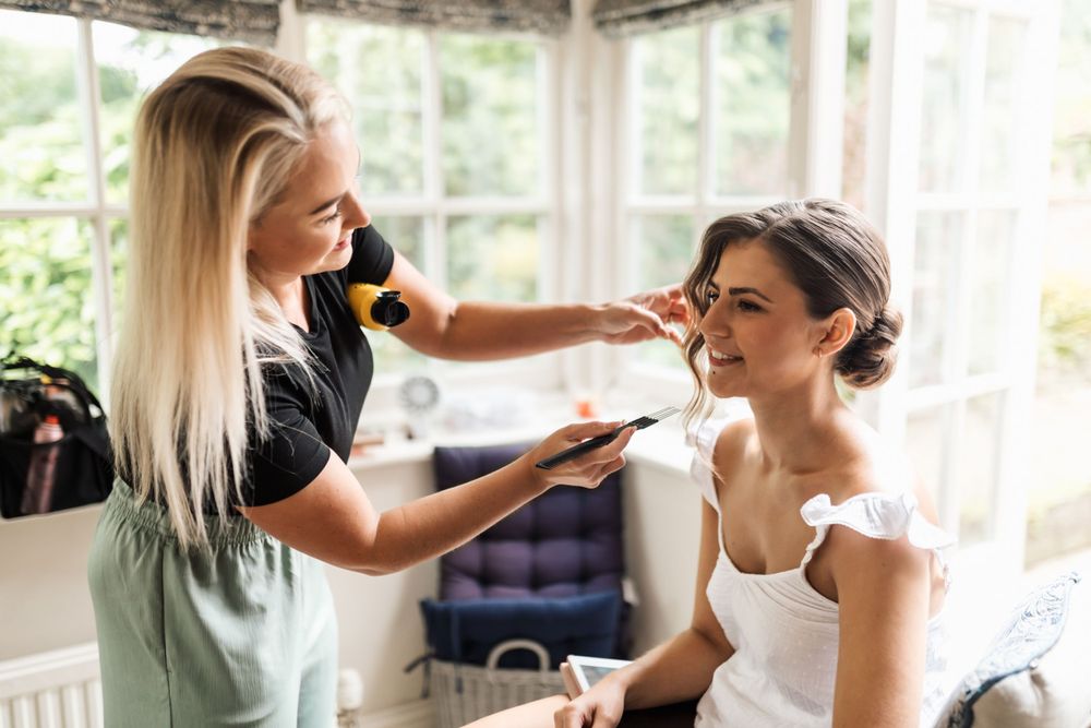 Wedding preparation scene showing final touches being applied in a bright sunlit room.