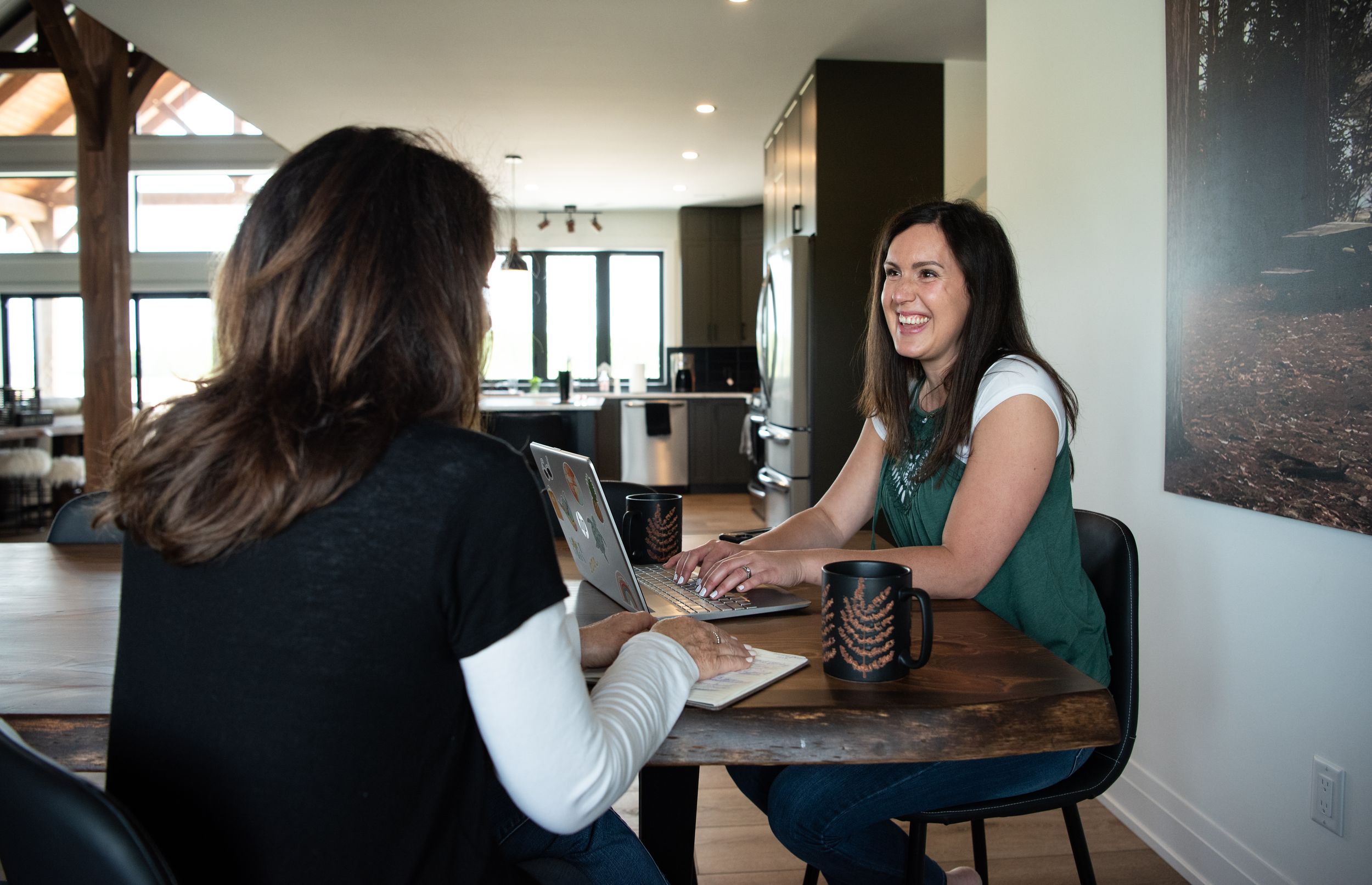 People collaborate and work together at a modern office space with large windows and natural lighting.