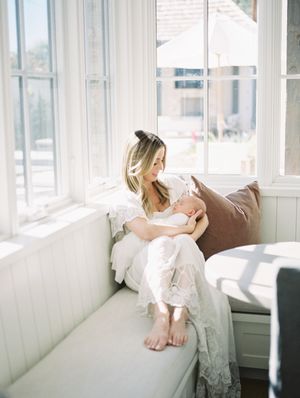 Peaceful sunlit moment in a window seat with natural light streaming through white curtains.