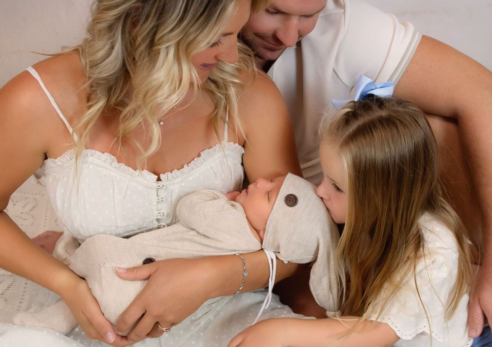 Intimate nursing photography session with soft white fabric and natural lighting.