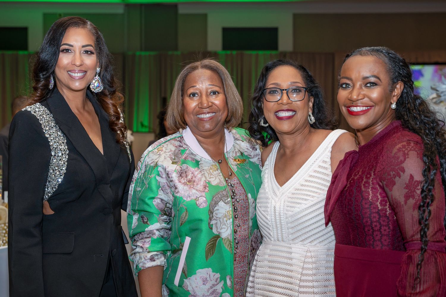 Formal event gathering with attendees in elegant dresses and festive attire.