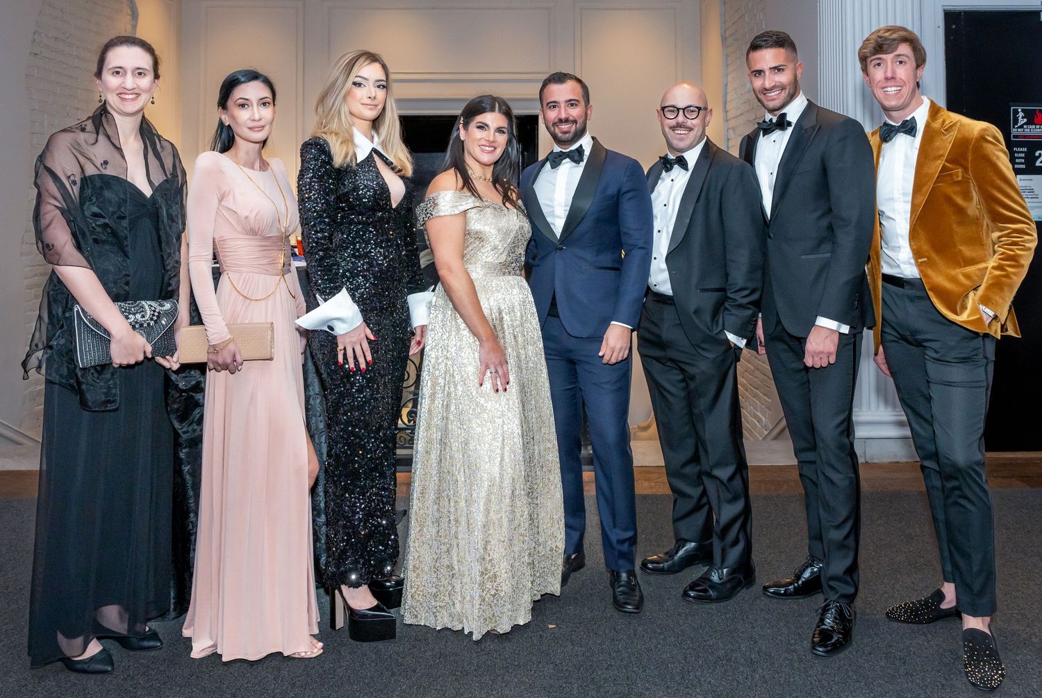 Group photo of formally dressed attendees at an elegant black tie gala event.