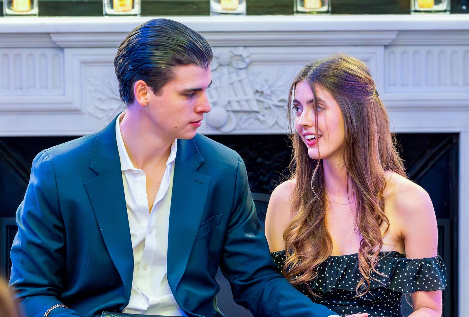 Young couple in formal attire share an intimate moment at an elegant venue.