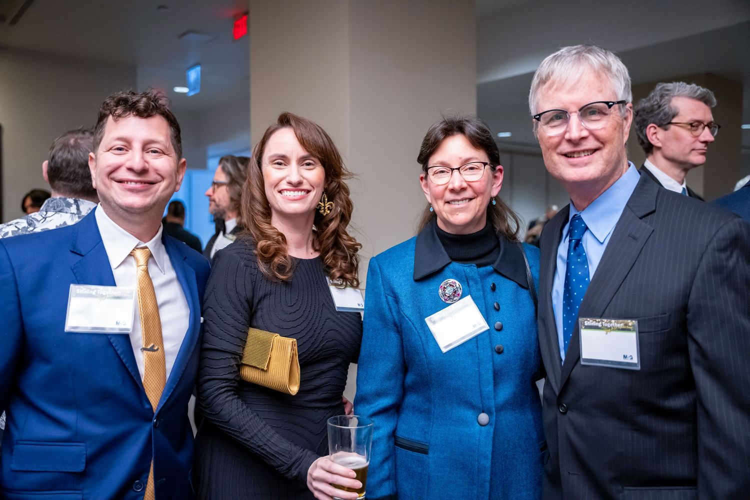 Group of professionals pose together at a networking event wearing name tags.