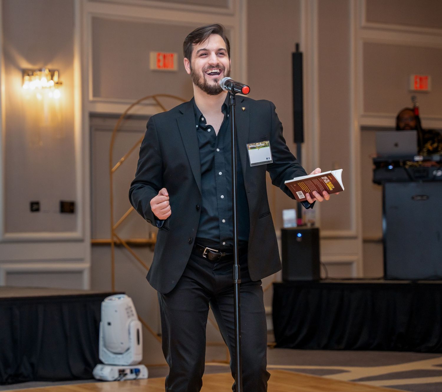 Professional speaker presenting on stage at a formal business event.