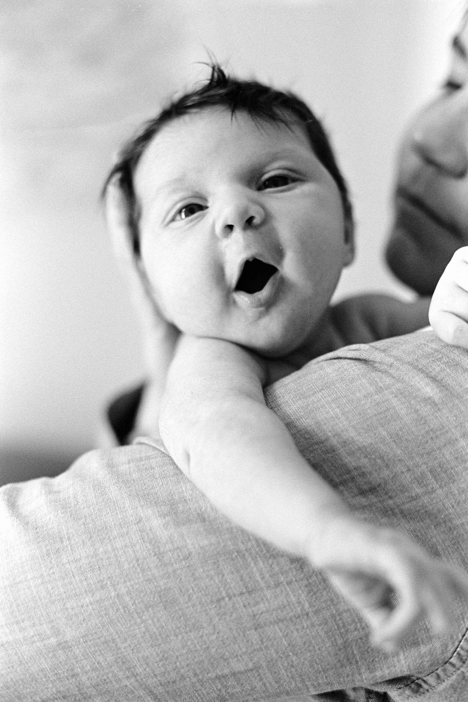 Close-up black and white sequence of an infant resting on textured fabric.