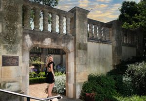 A series of concrete structures with white balustrades and landscaped greenery create a peaceful garden walkway scene.