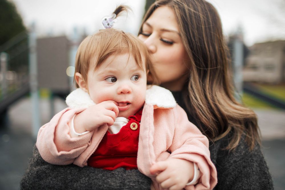 Everett WA family photographer: a mother kisses her toddler daughter at a photo session in Silverlake Everett WA