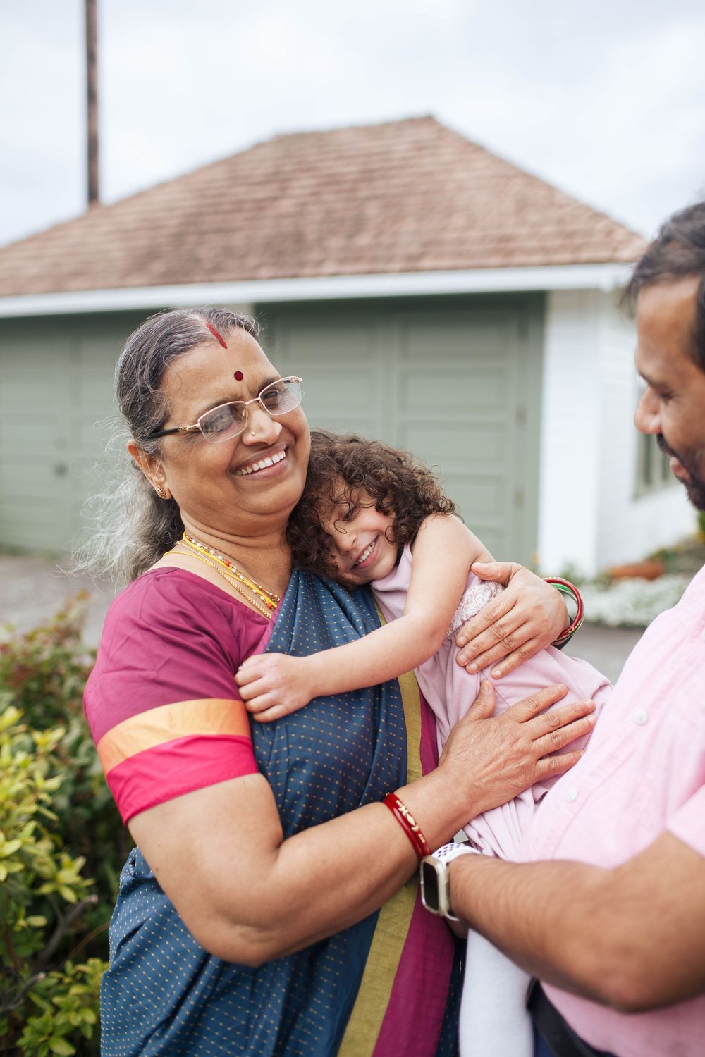 Mukilteo lighthouse family photos: A grandmother wearing a sari holds her granddaughter during a family photo session