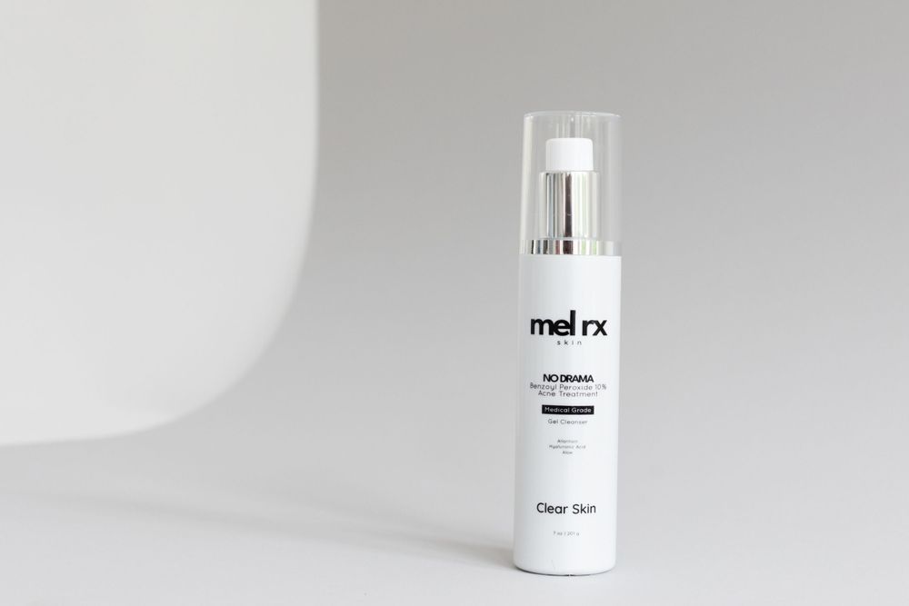 White minimal skincare bottle with mel rx branding on clean white background against soft shadow.