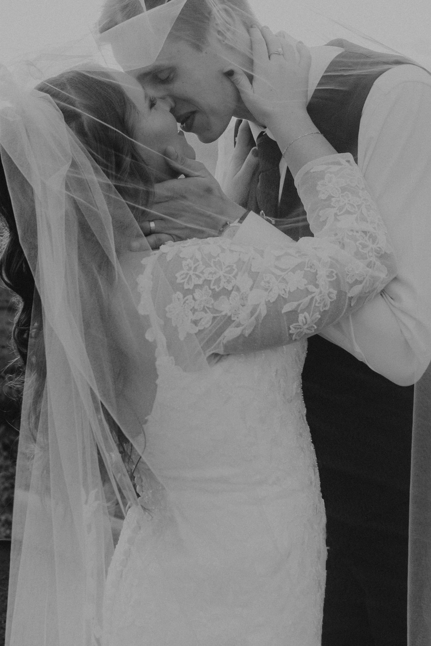 A series of black and white wedding photos showing intimate moments between a bride and groom during their first kiss.