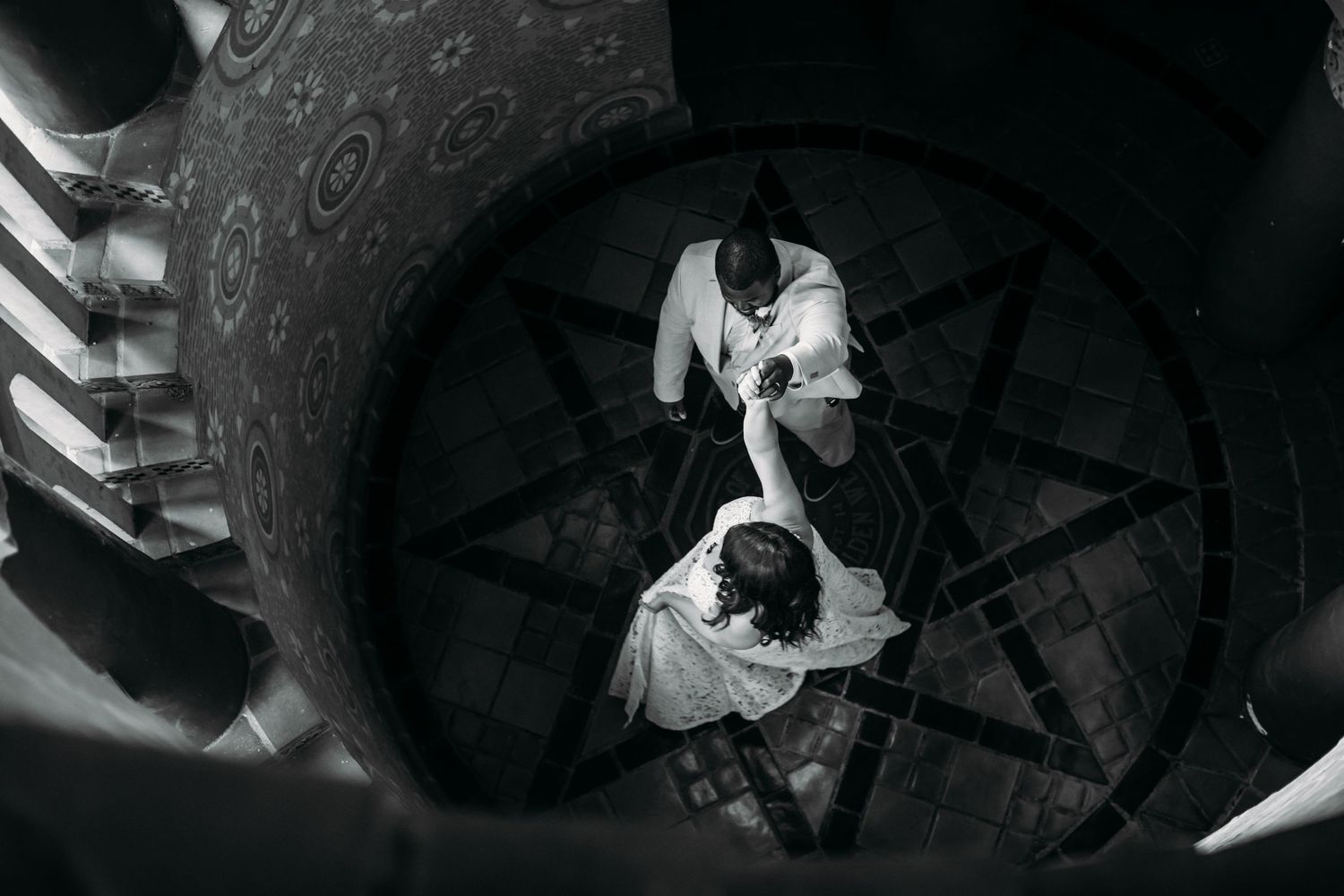A dramatic black and white overhead view on a spiral staircase.