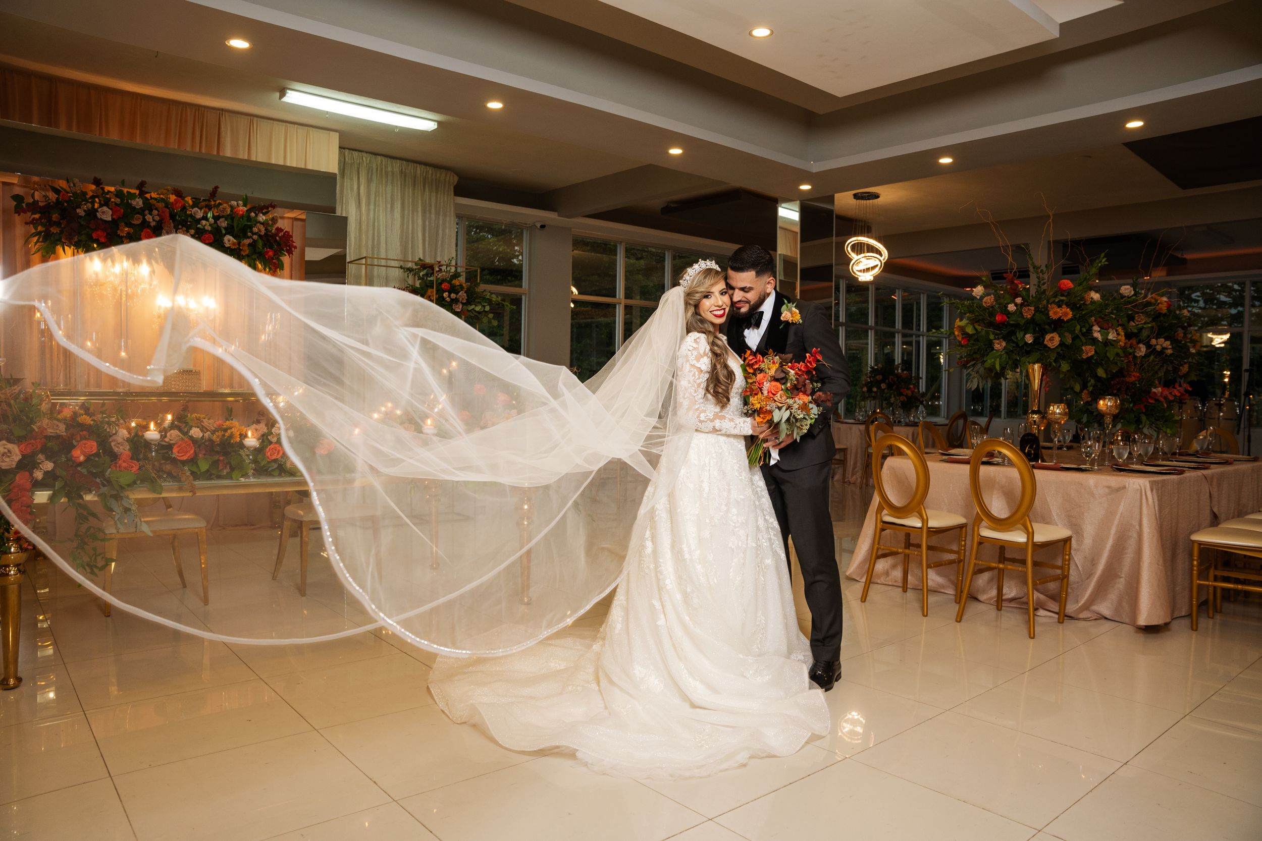 Wedding photo capturing a flowing veil moment in an elegant reception hall.