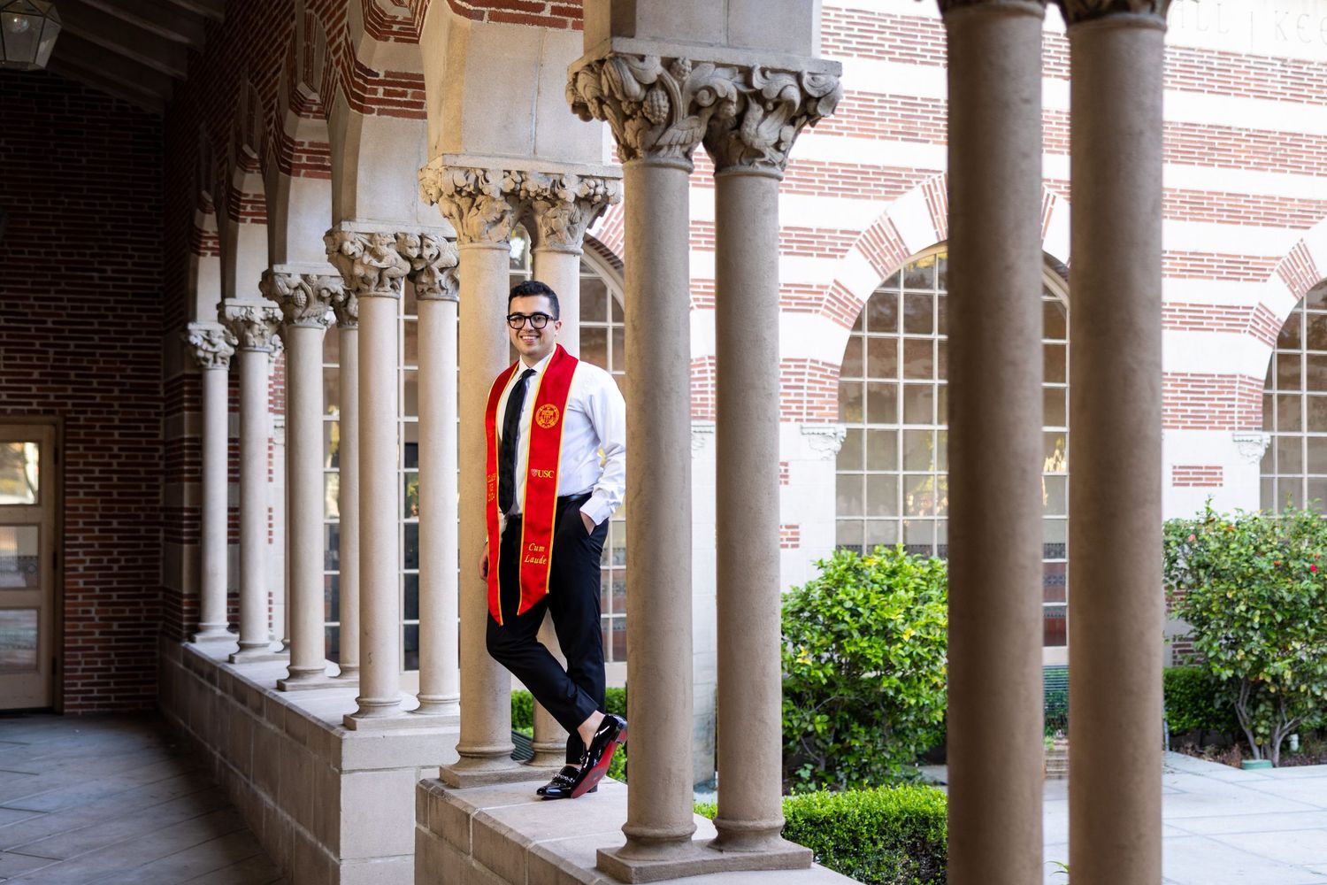 An academic corridor features beautiful columned architecture and ornate stone details.