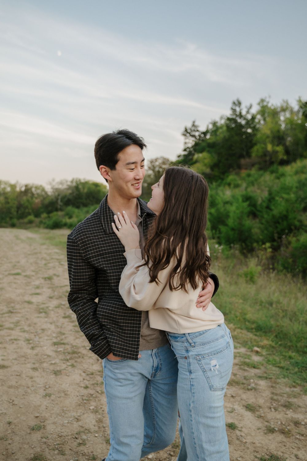 A couple hugging on top of a hill