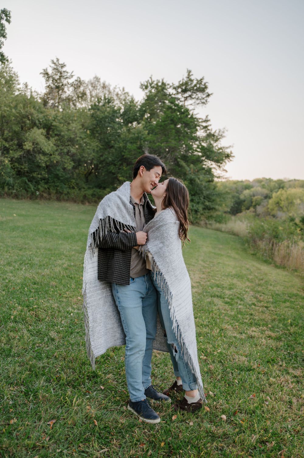 Couple wrapped up together in a blanket kissing