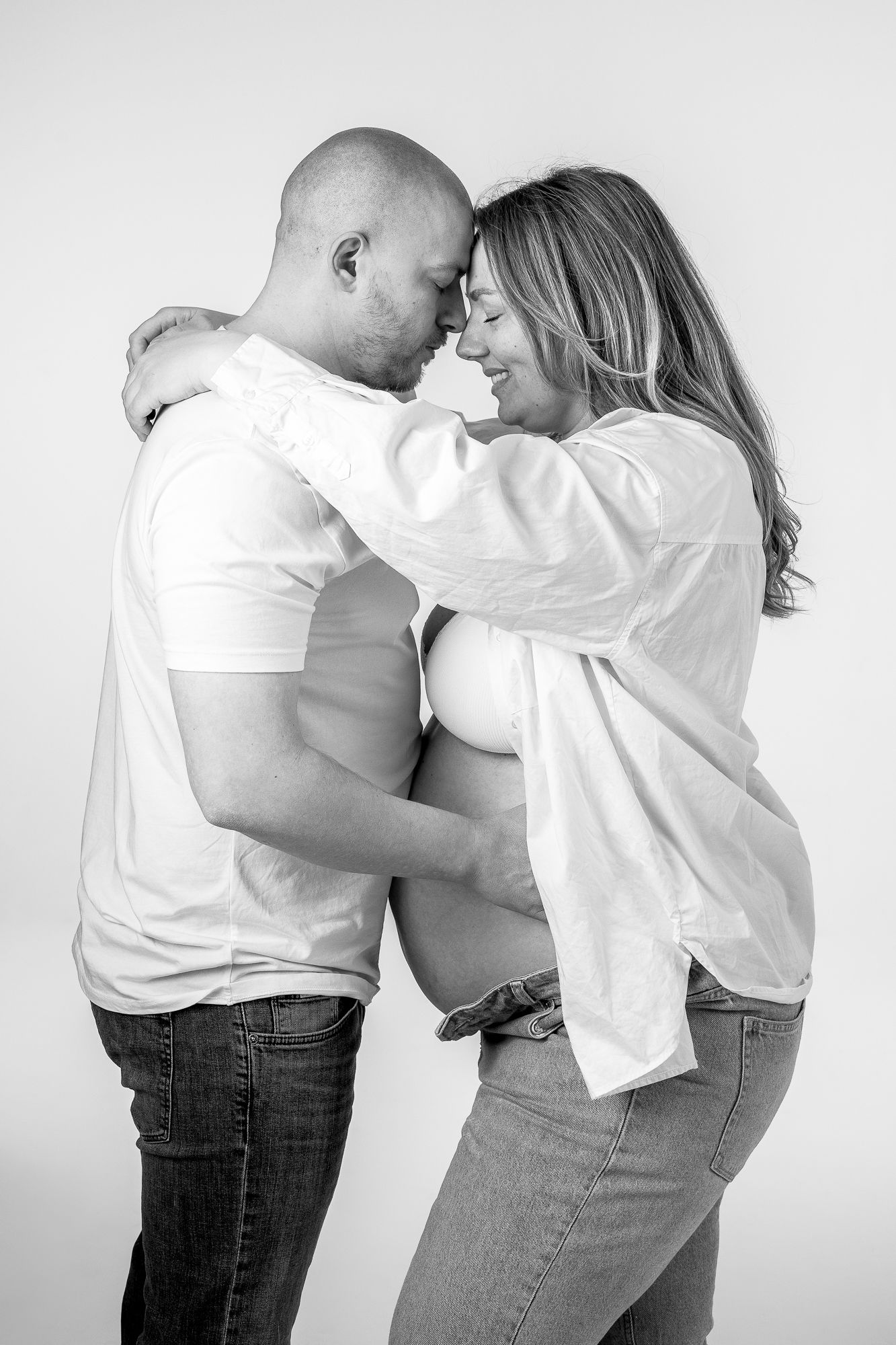 Black and white intimate portrait of a loving couple in casual clothing sharing a tender moment together.