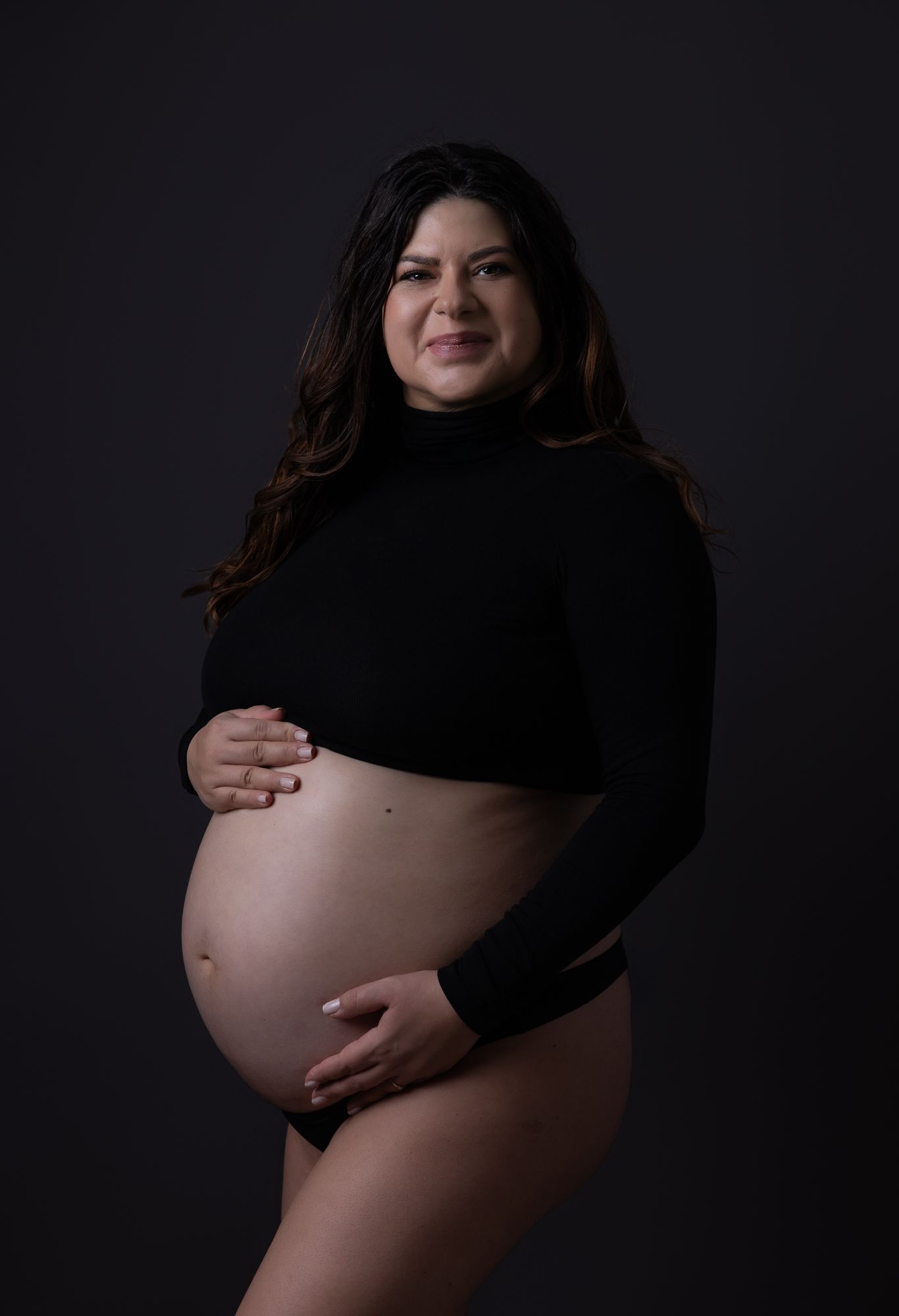 A dramatic artistic maternity photo sequence showing a pregnant silhouette against a dark background.
