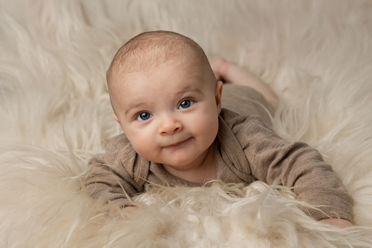 close-up photos showing a baby wrapped in soft beige blankets with sweet expressions.