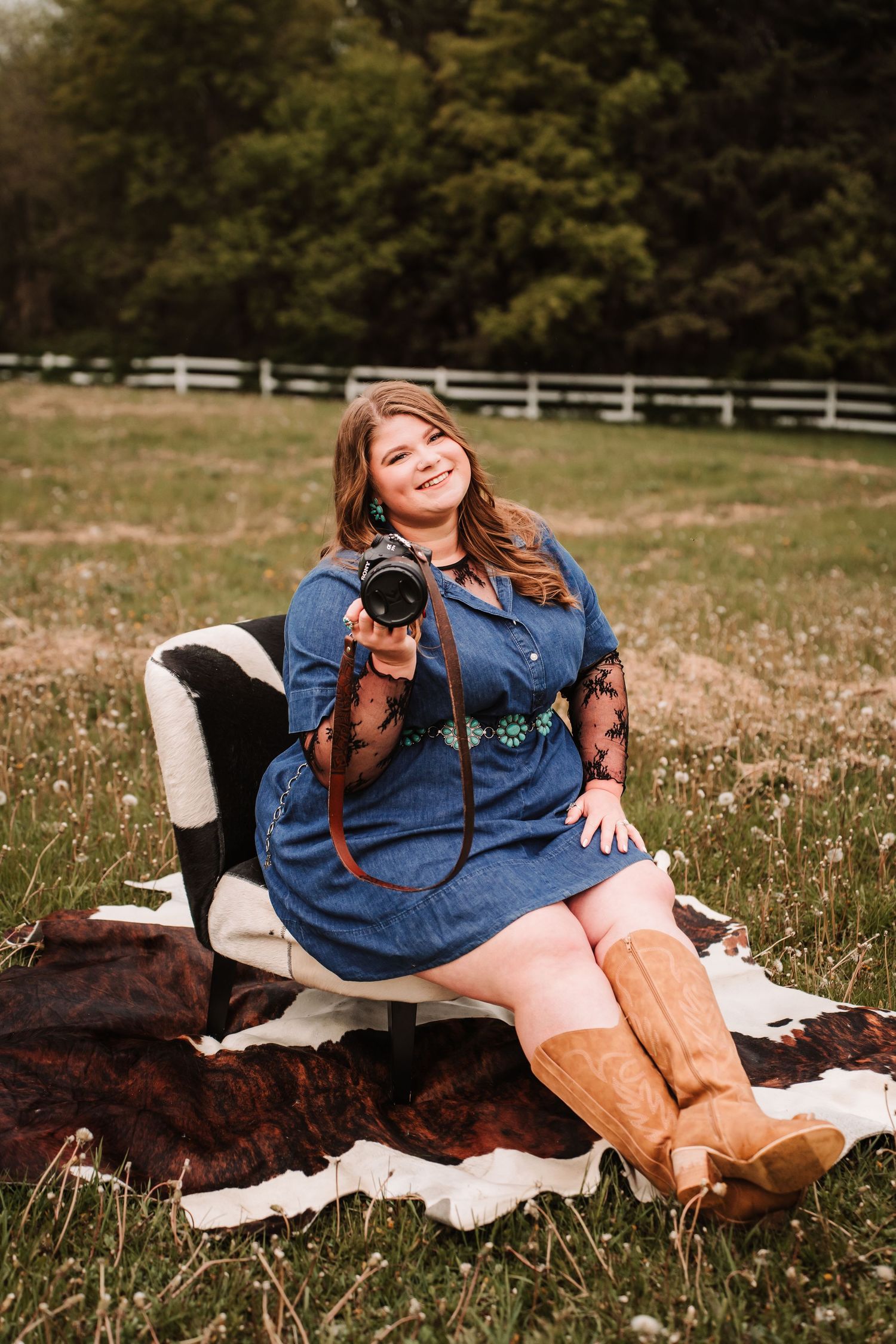 Person hugging a friendly Highland cow in a green pasture during sunset.
