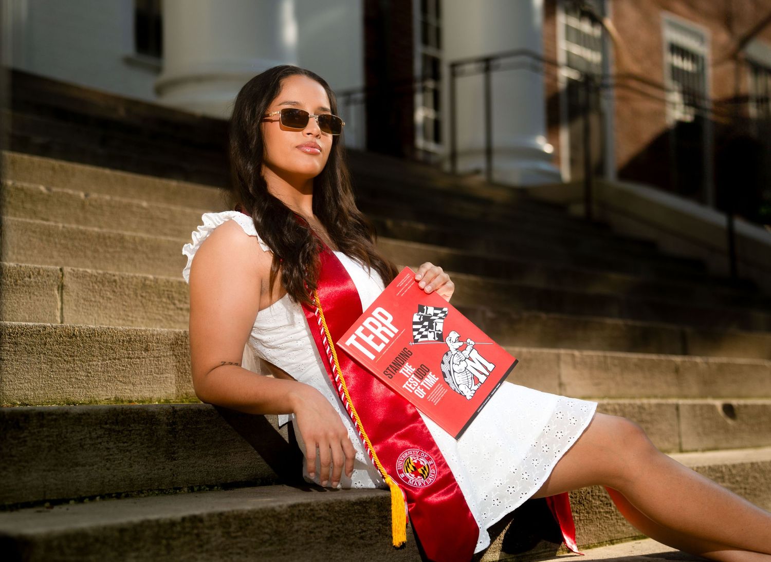 Athletic photoshoot on stone steps in red and white sportswear.