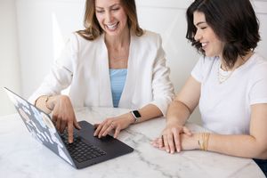 woman SEO strategist personal branding lifestyle photo with female client pointing at laptop sitting at table business owner in Seattle, WA