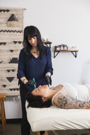 maple valley acupuncture woman using micro needling on woman's face for treatment service personal branding photo