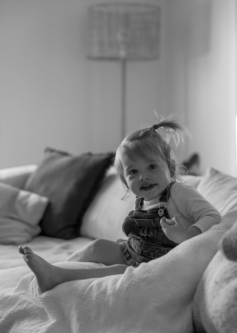 Toddler smiling on the couch – In-home newborn photoshoot in Wollongong by Lovers and Bubs, natural family photography in the Illawarra.