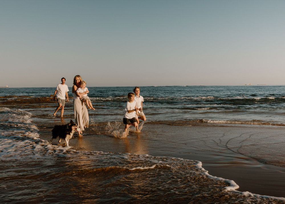 Family of five with three boys and dog playing together outdoors at Bellambi Beach- family and pet photography in Wollongong, Woonona, Bulli