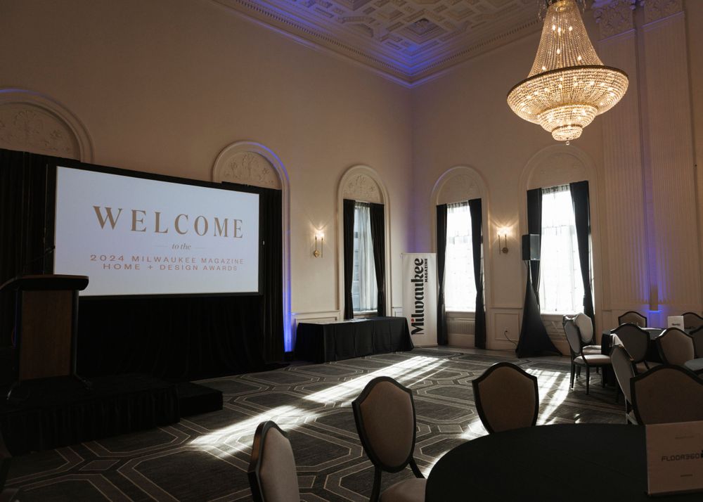 Elegant conference room with crystal chandelier and welcome screen projection.