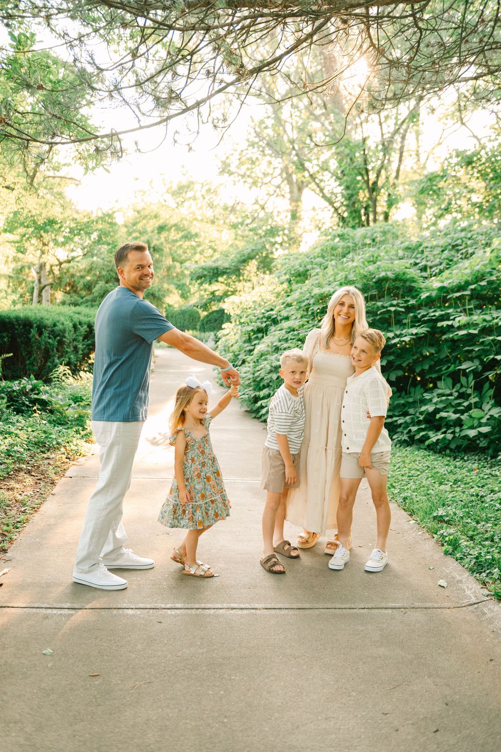 Family members lined up on a garden path performing a fun dance routine together.