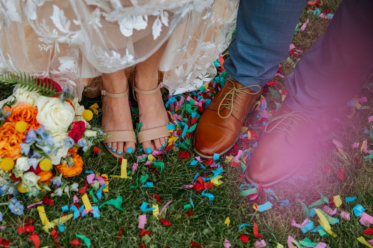 A romantic scene under a stone archway with blooming purple flowers in the foreground on a cobblestone path.
