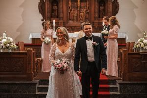 Wedding party stands arranged in front of a traditional church altar during an elegant ceremony.
