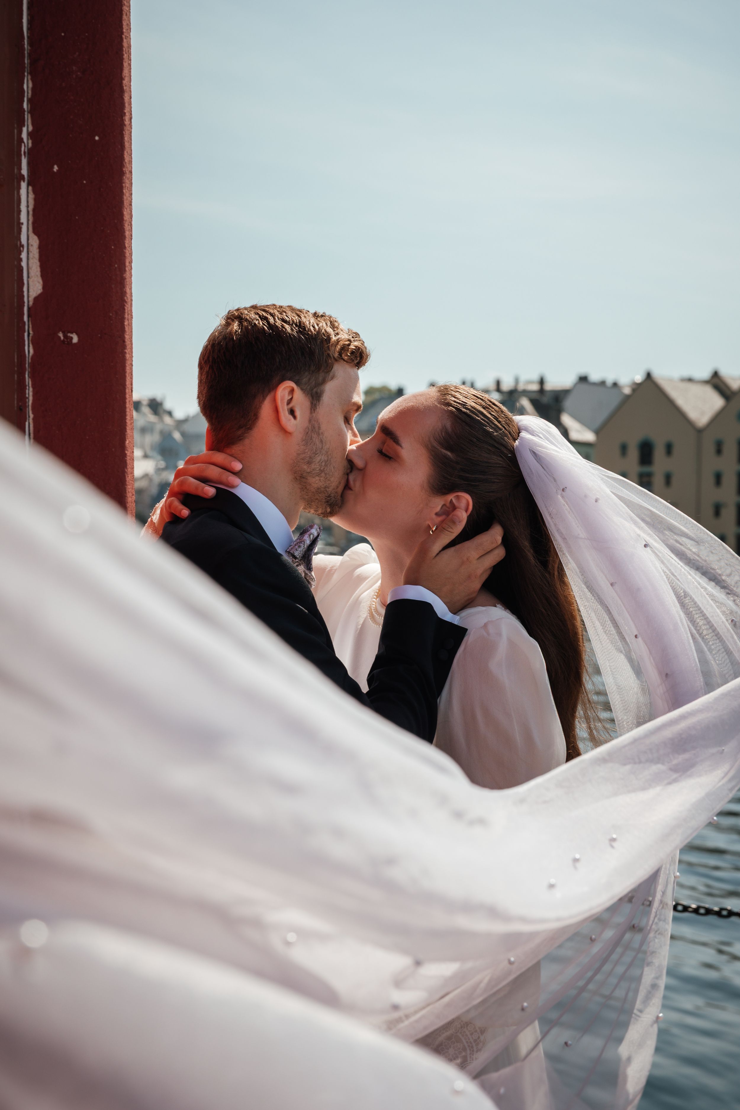 A romantic wedding photo sequence showing a bride's veil flowing gracefully in the wind as the newlyweds kiss.