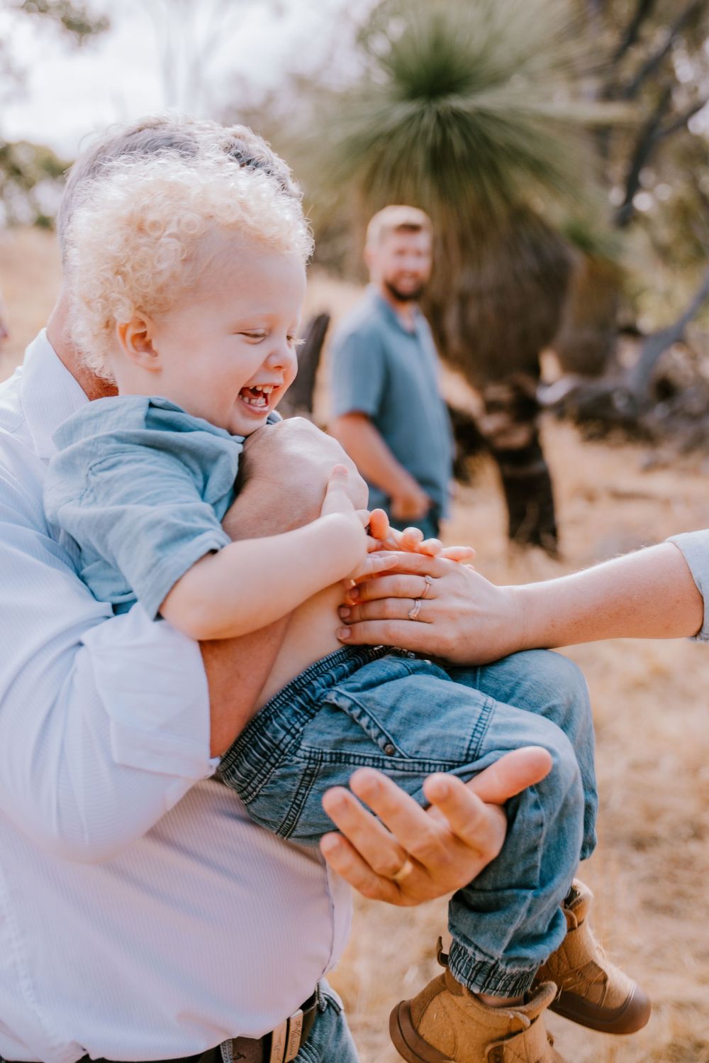 Playful tickling moments captured during an outdoor family photoshoot.