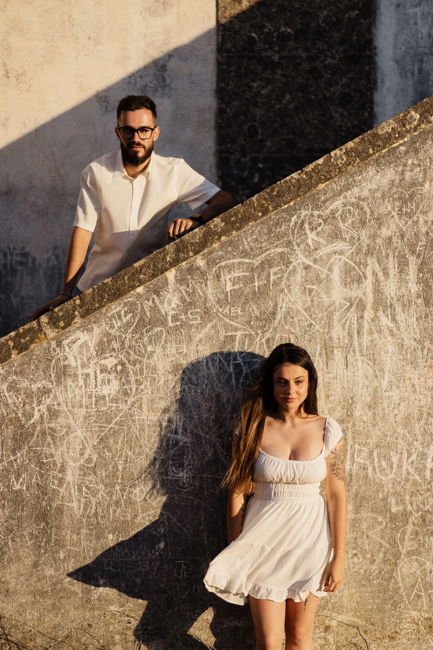 Creative wedding photography through a window opening in a concrete wall.