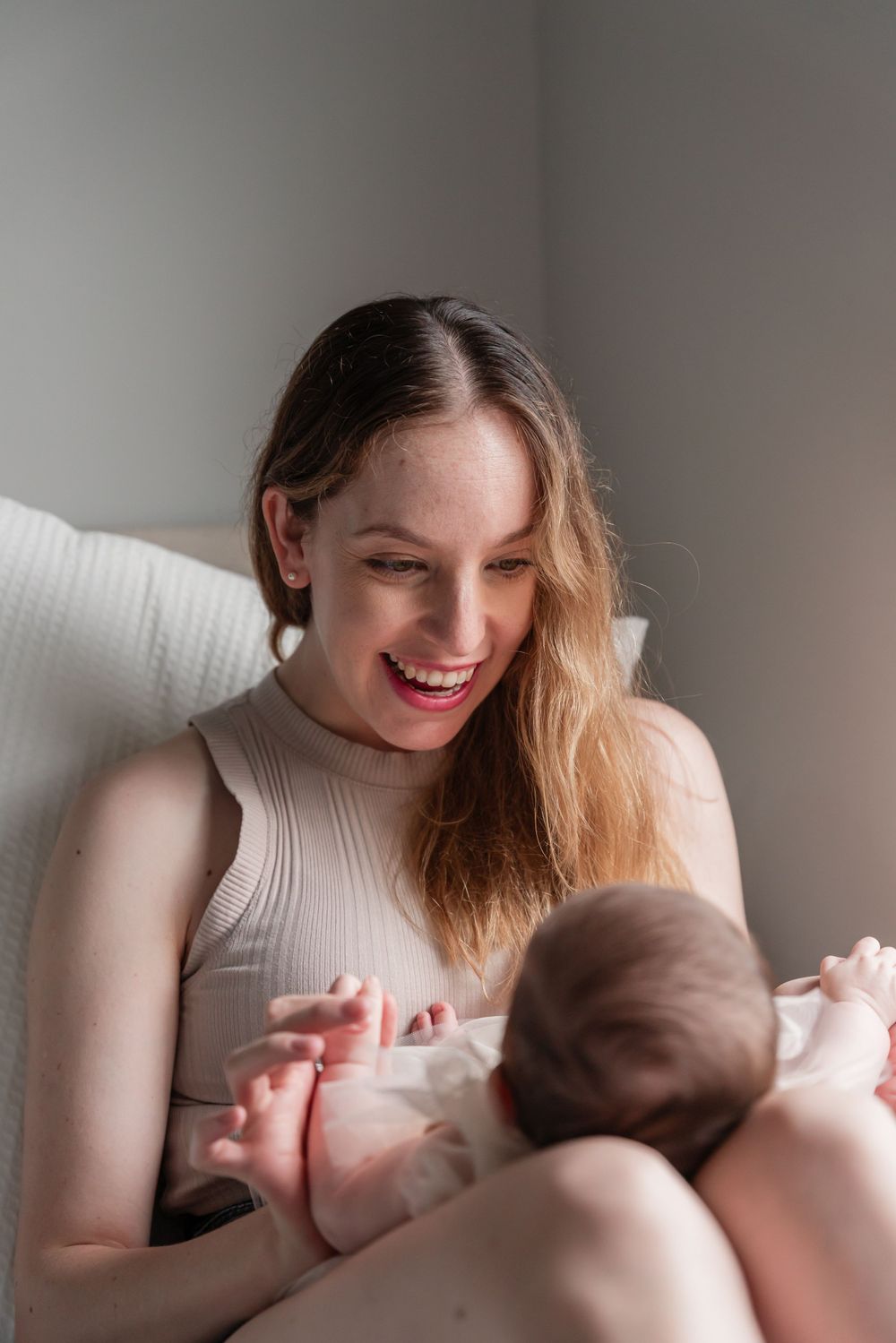 Parent and infant share joyful moment in soft natural light.
