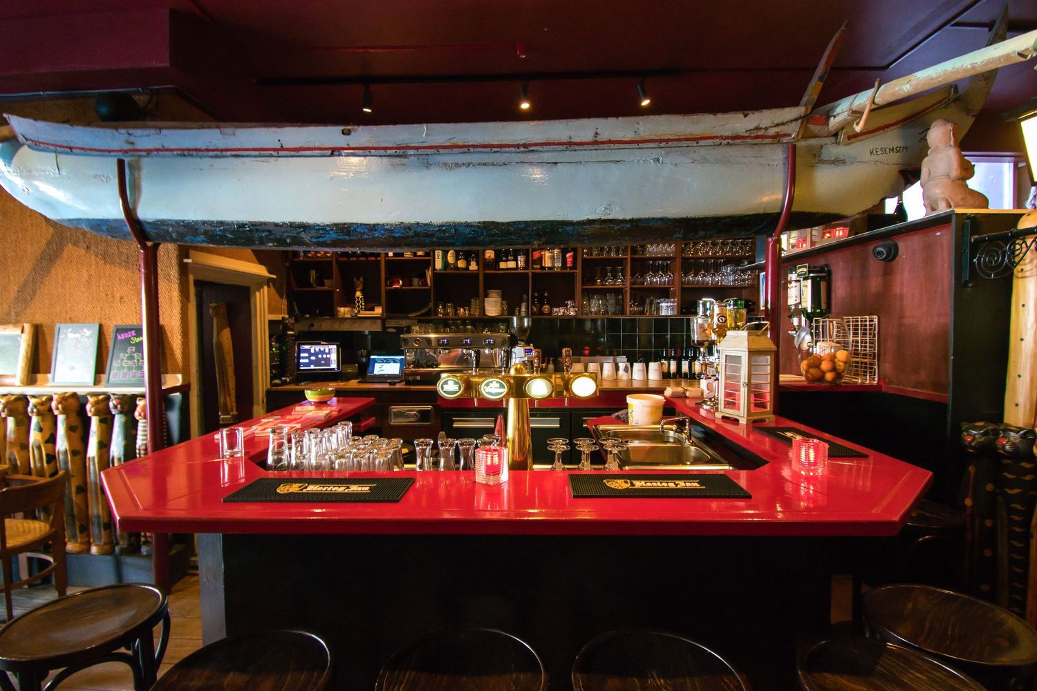 Interior panoramic view of a dimly lit upscale bar with red accents and modern decor showing multiple seating areas.