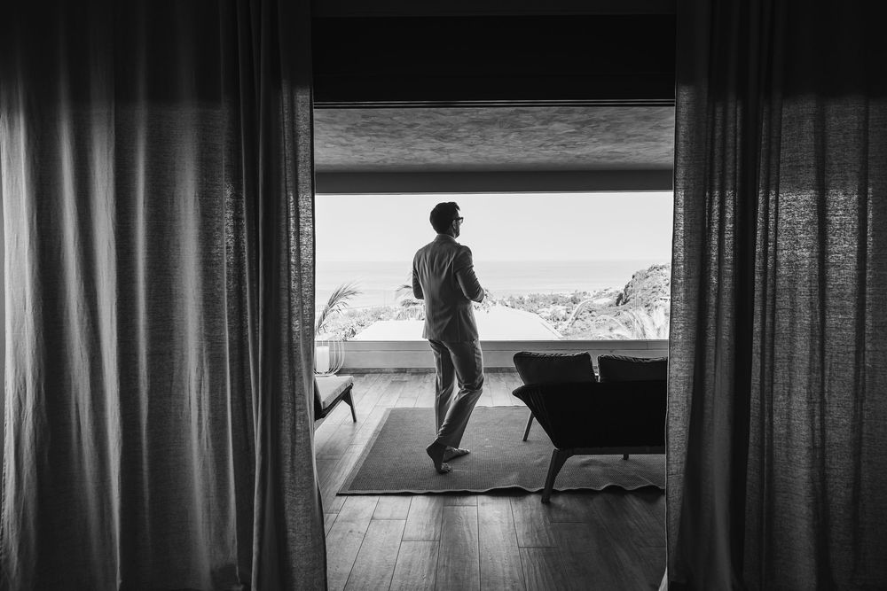 Silhouetted figures stand in doorways and windows creating a dramatic black and white composition.