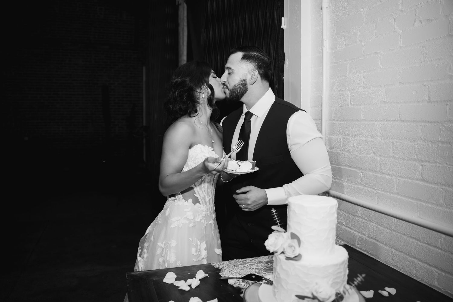 A series of black and white wedding photos showing the couple cutting cake and sharing romantic moments at their reception.