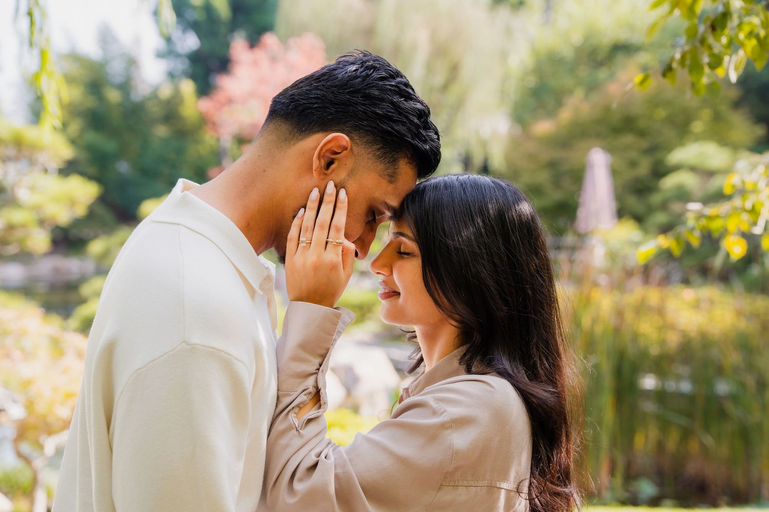 Romantic couple shares intimate moments in a lush garden setting during golden hour photography session.