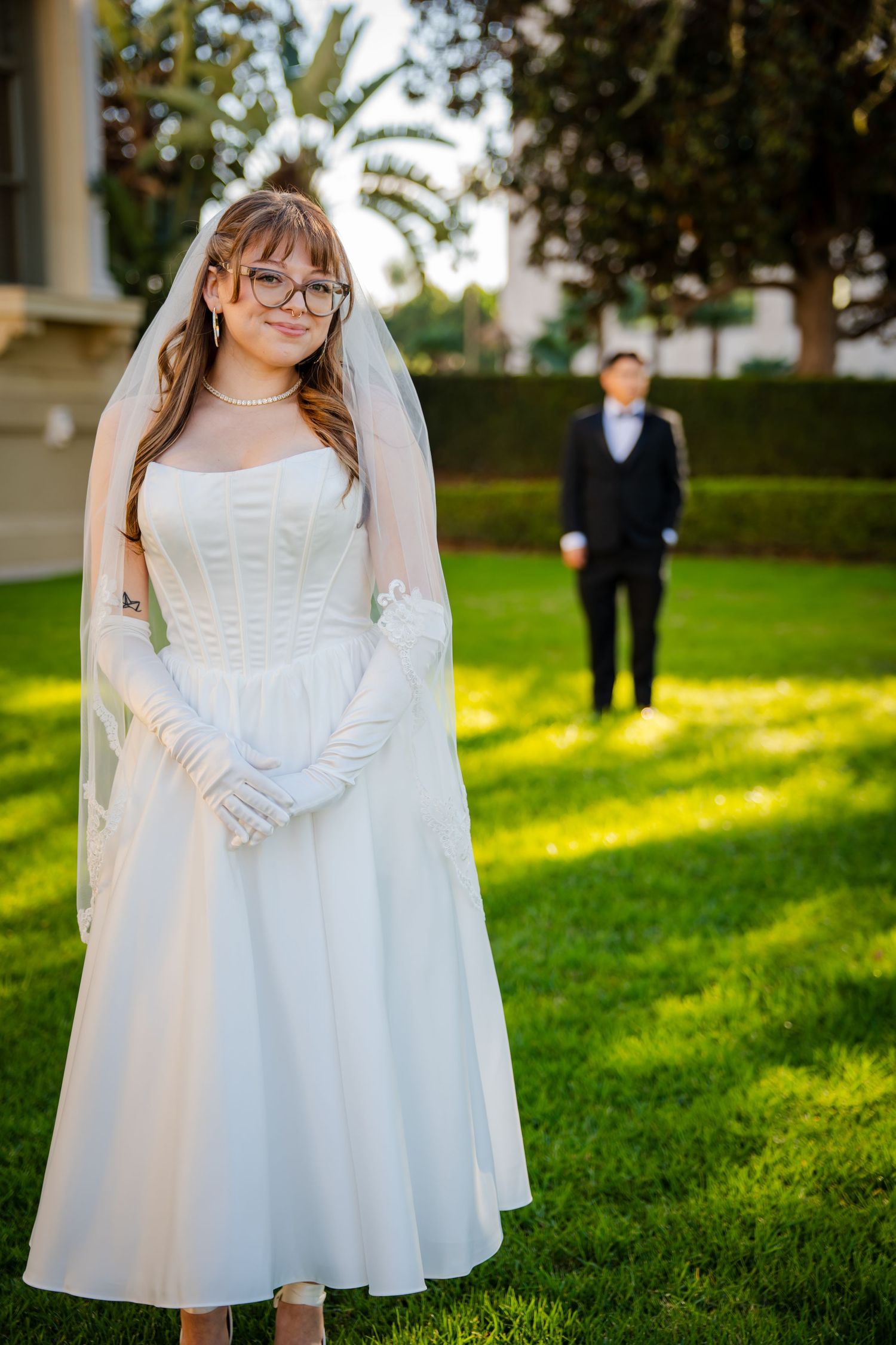 A series of photos showing a flower girl in a white dress and veil standing on a sunlit lawn.