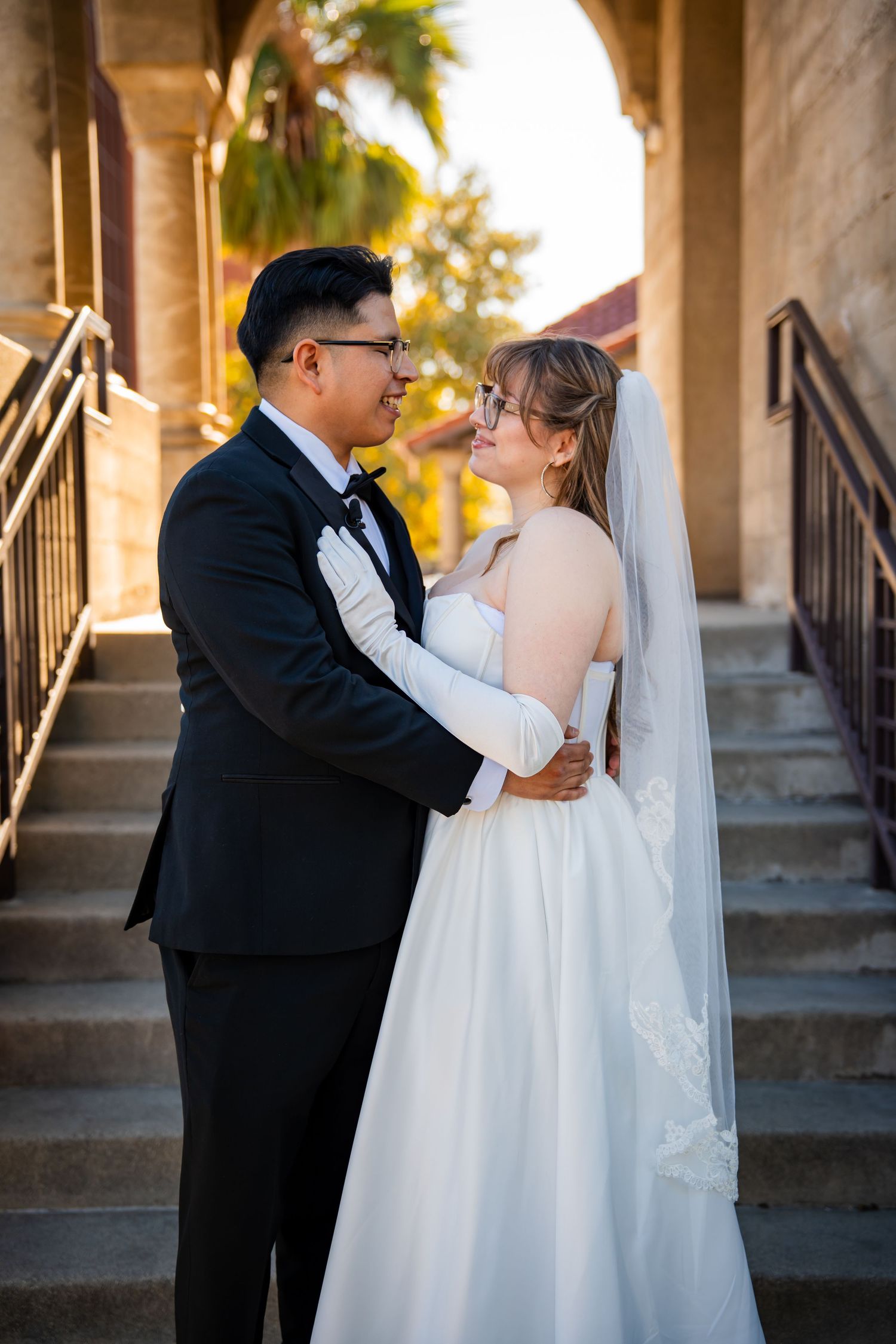 A romantic sequence of wedding photos showing a couple in formal attire embracing on stone steps at sunset.