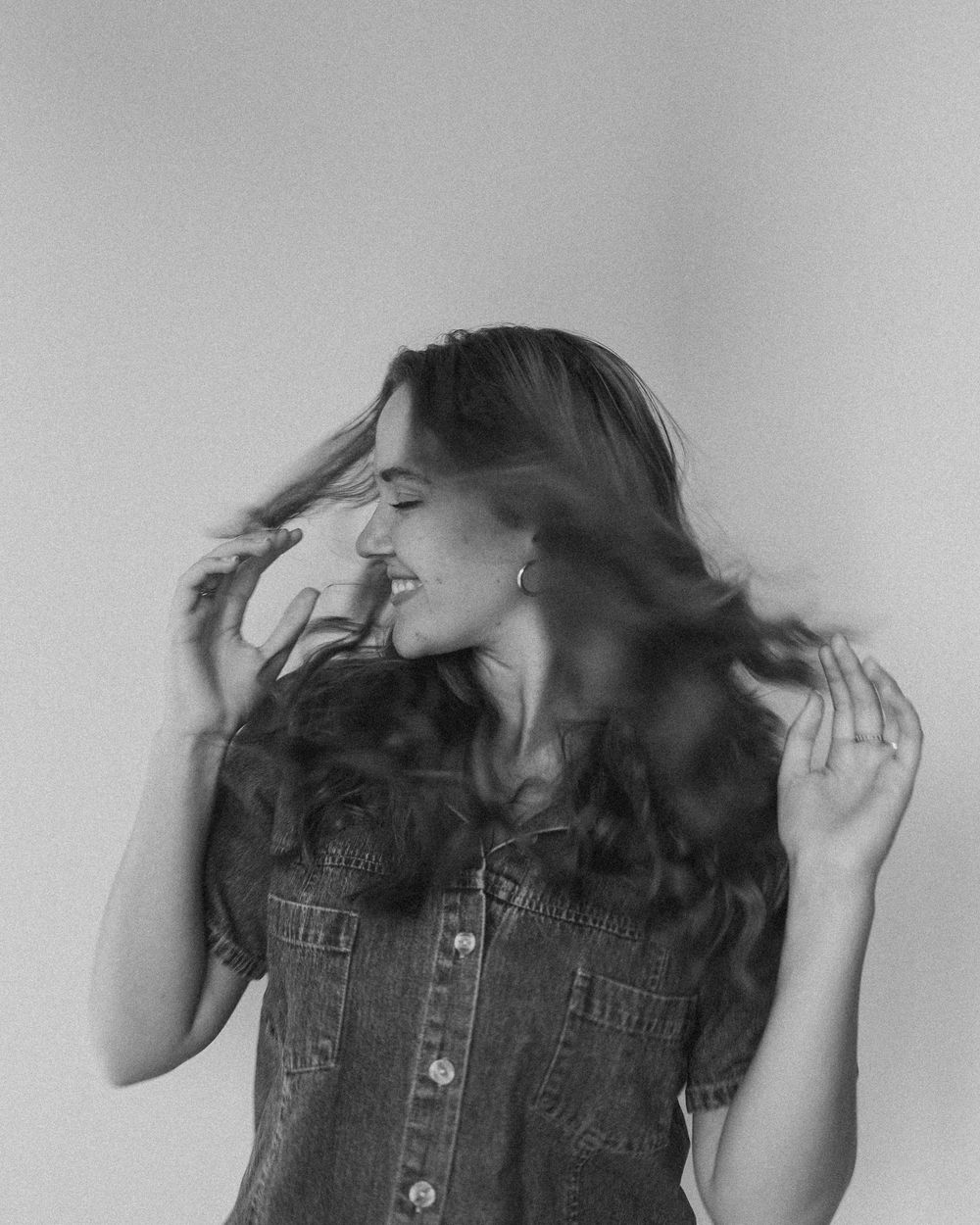 A sequence of four black and white photos showing dynamic hair movement against a plain background.
