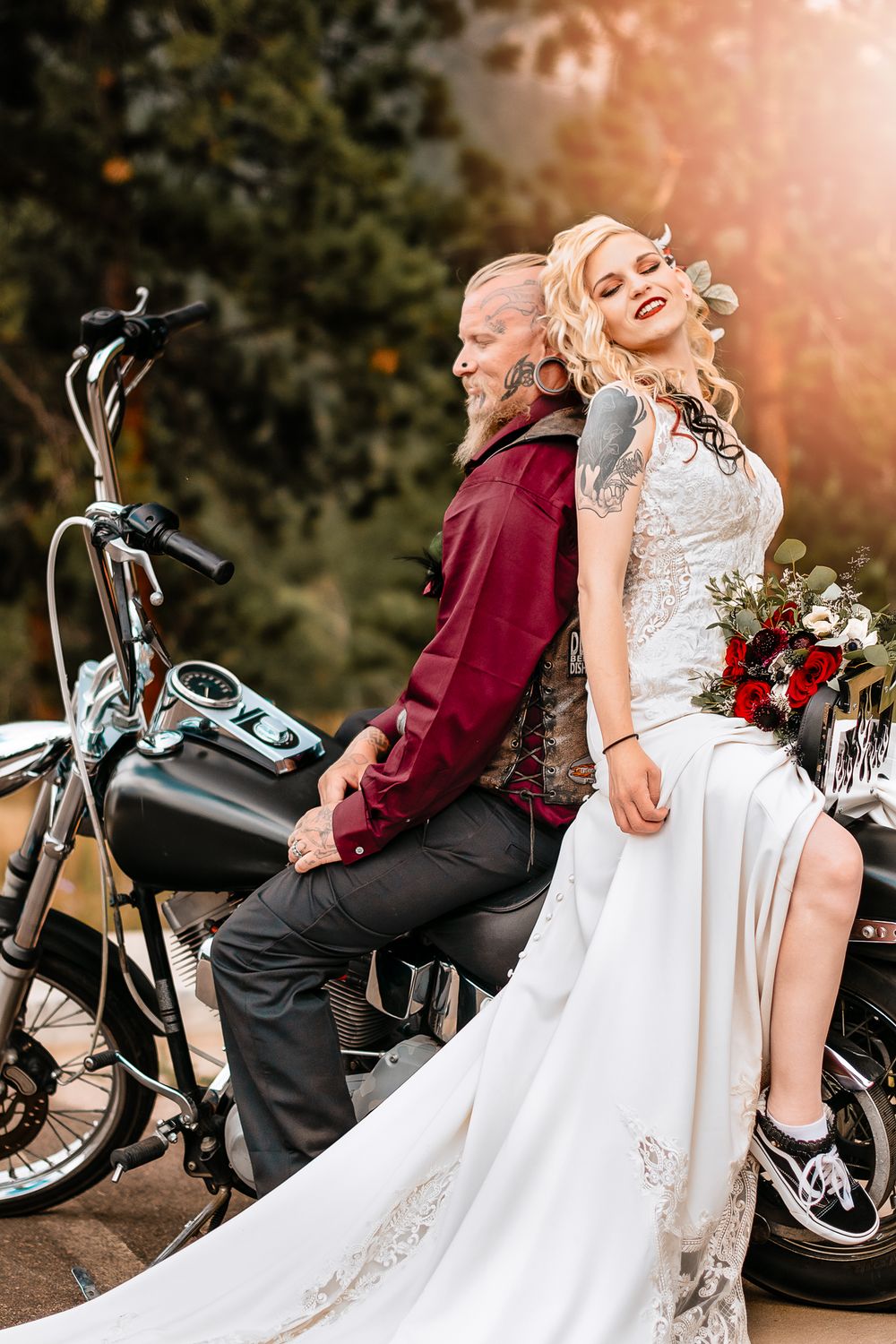Alternative bride and groom posed on their motorcycle in the woods at Staunton State Park