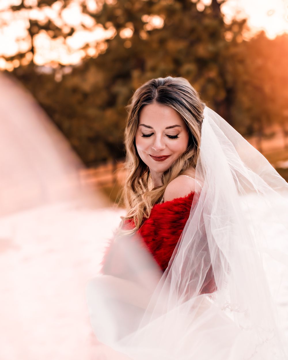 Woman posing for her bridal portraits with her veil framing her