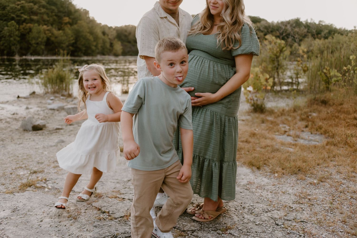 Family walking together on outdoor path during golden hour photoshoot.