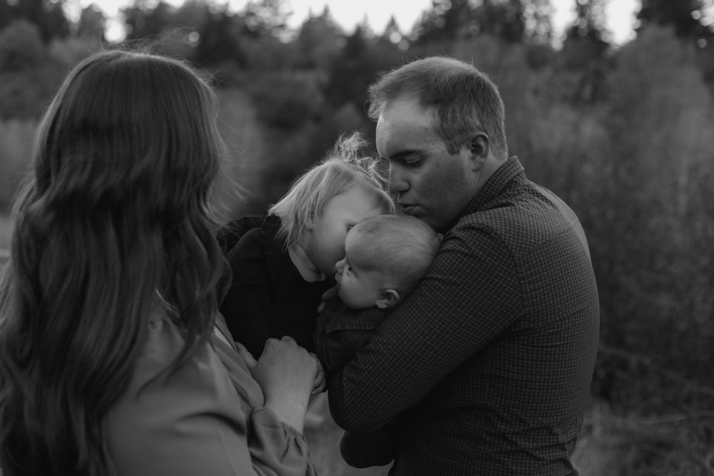 Romantic scene captured in black and white tones against natural outdoor setting.